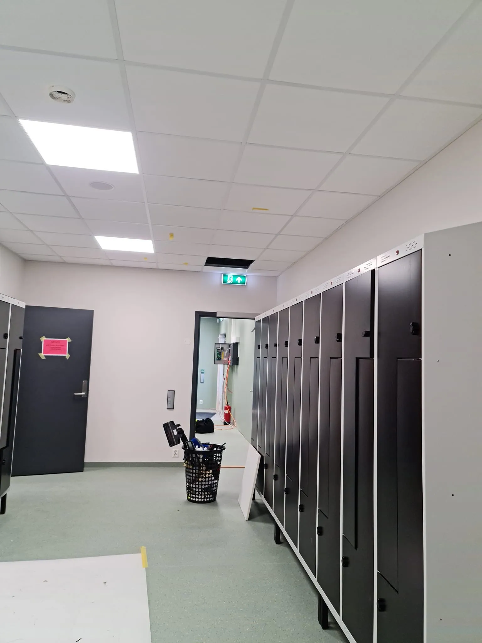 Garderobe i næringsbygg under byggvask med utstyr på gulvet