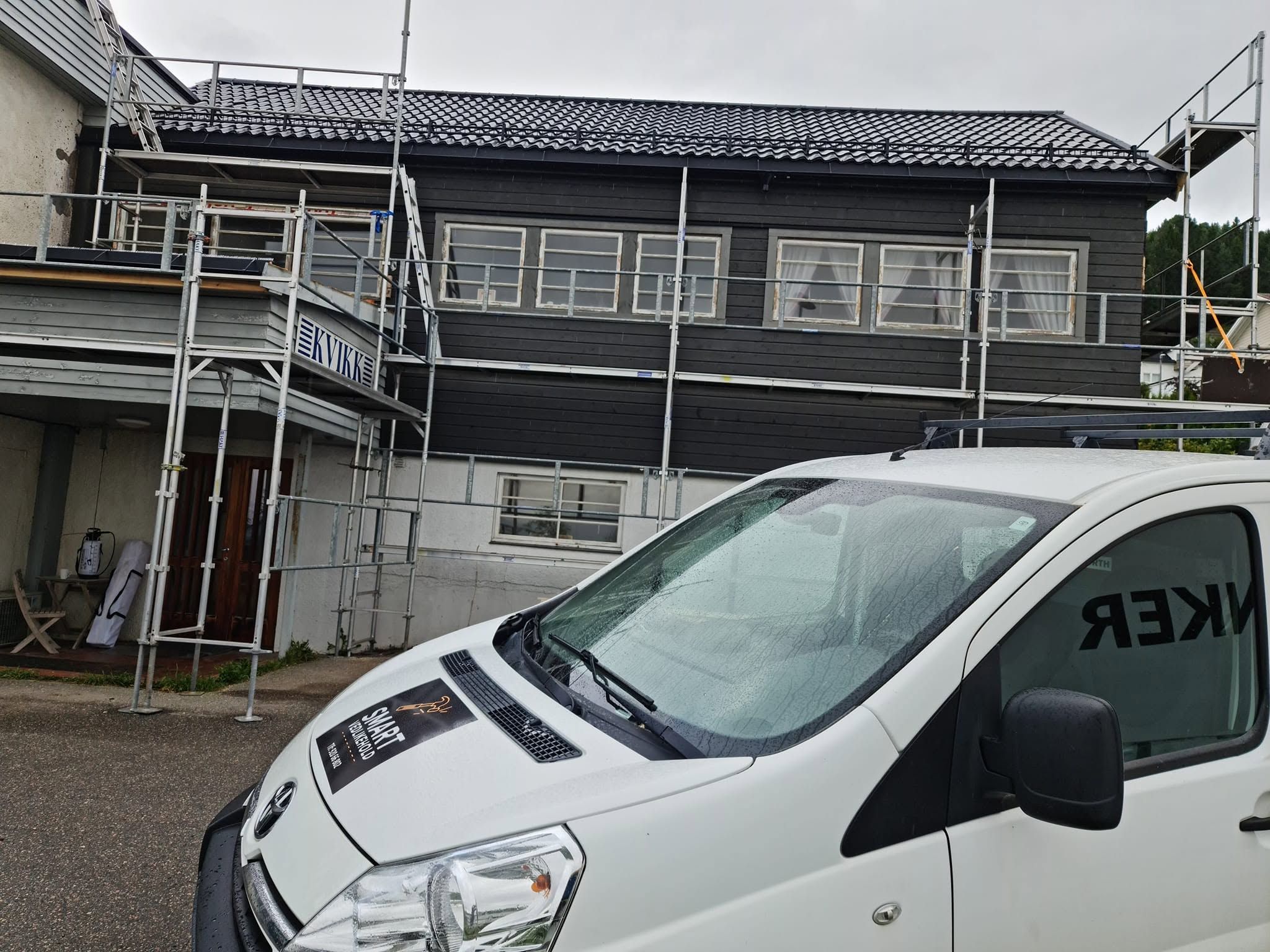 Firmabil fra Smart Vedlikehold foran bolig med stillas