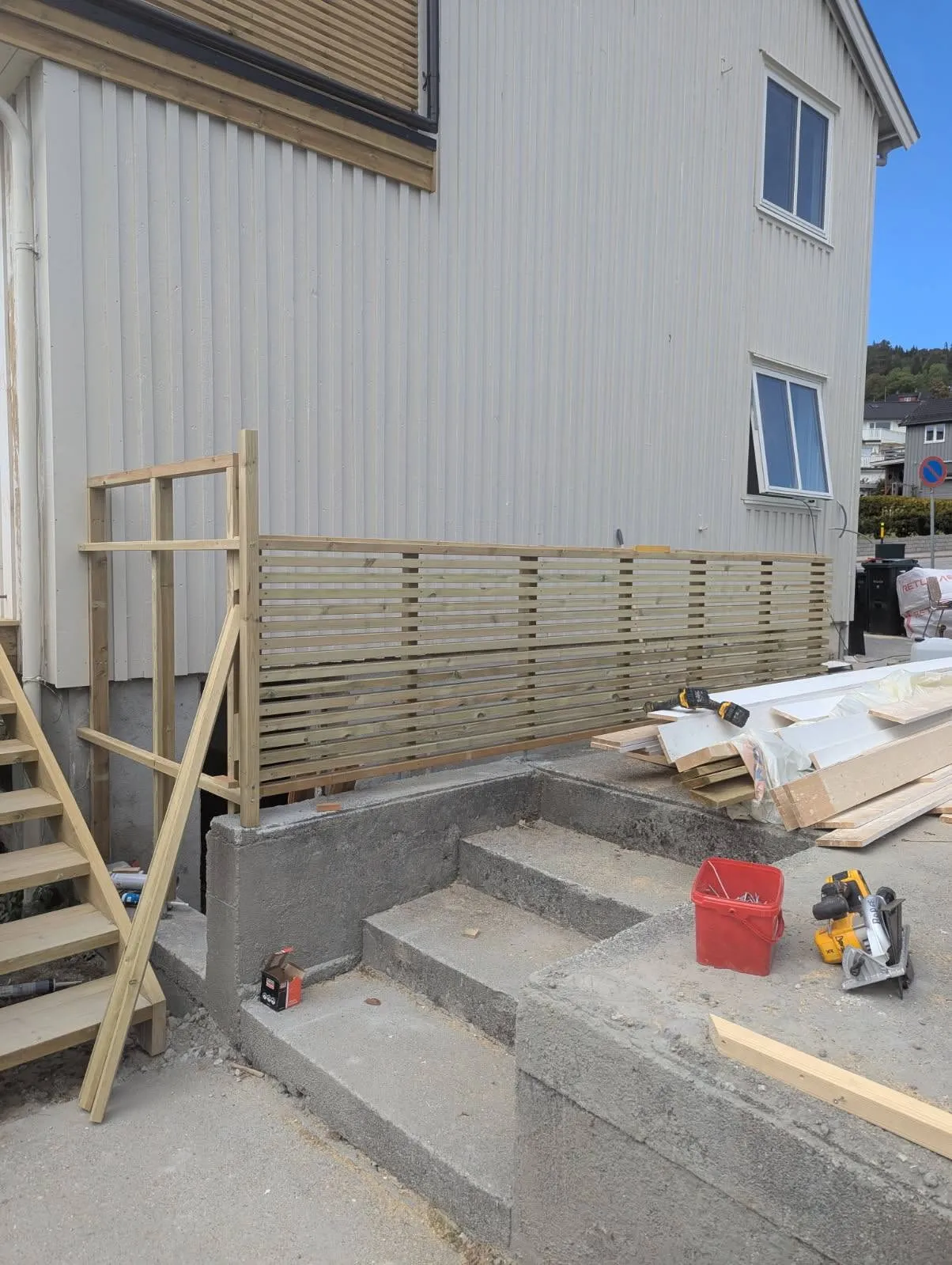Spilerekkverk montert langs veranda over betongtrapp
